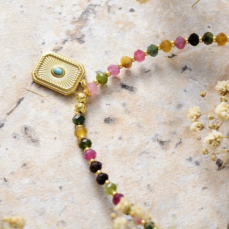 Necklace with gold clasp and multicolored beads on a textured surface